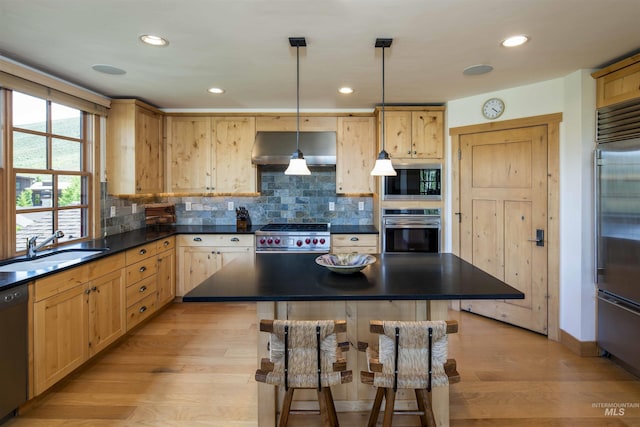 109 Angani Way Unit 15, Sun Valley, ID 83353 - kitchen with premium appliances, extractor fan, dark countertops, a breakfast bar area, and light wood finished floors