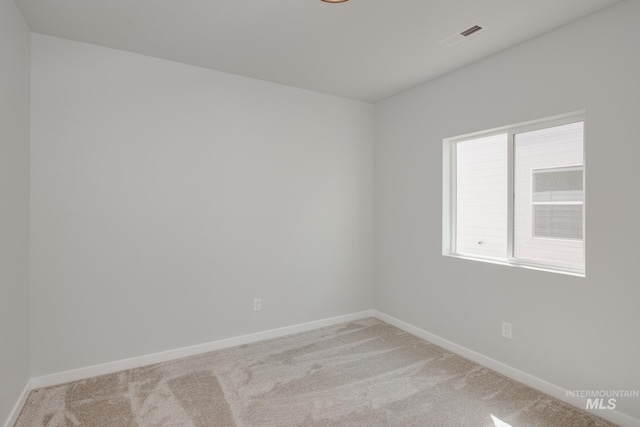 carpeted empty room with baseboards and visible vents