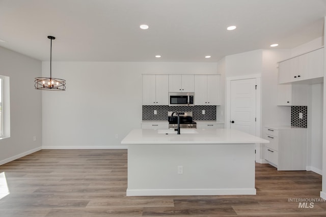 kitchen featuring a sink, stainless steel appliances, light countertops, white cabinetry, and light wood-type flooring