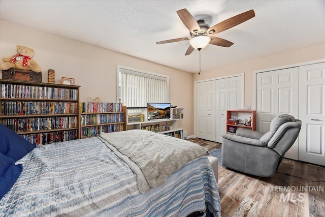 bedroom with hardwood / wood-style flooring, a textured ceiling, and ceiling fan