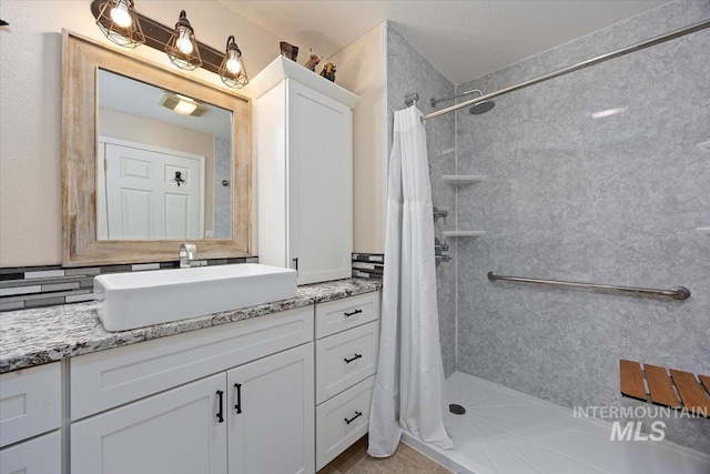 bathroom with vanity, backsplash, walk in shower, and tile patterned floors