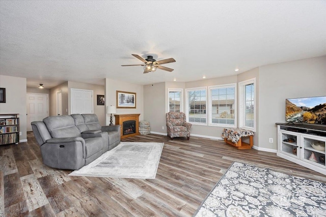 living room featuring hardwood / wood-style floors, a textured ceiling, and ceiling fan