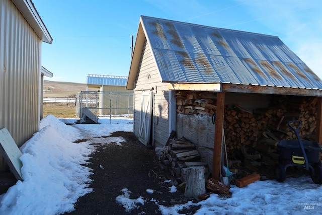 view of snowy exterior with an outbuilding
