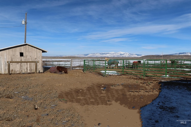view of yard with a mountain view, an outbuilding, and a rural view