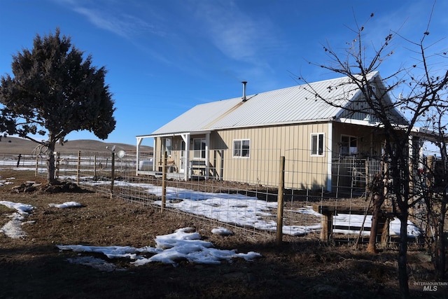 snow covered rear of property with a mountain view