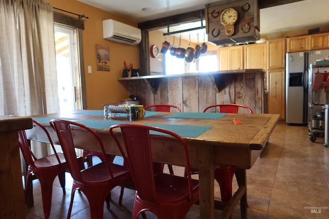 dining space featuring an AC wall unit and light tile patterned flooring