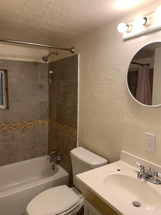 full bath with a textured ceiling, a textured wall, toilet, vanity, and shower / bath combo with shower curtain