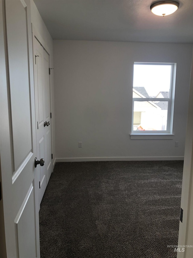 empty room featuring dark colored carpet