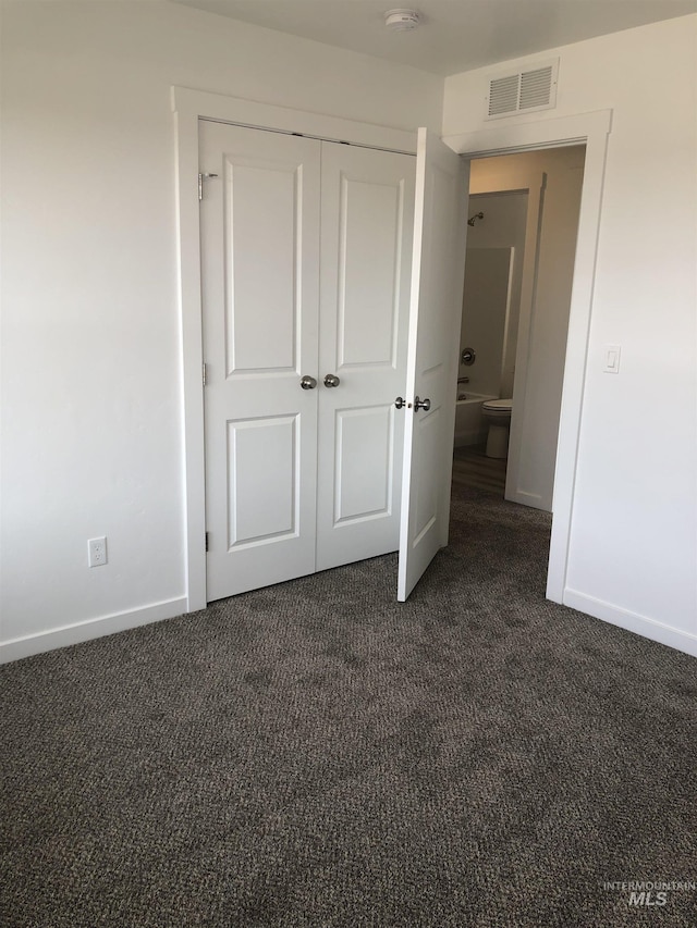 unfurnished bedroom with dark colored carpet