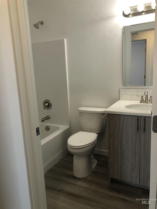 full bathroom with hardwood / wood-style flooring, vanity, toilet, and shower / bath combination