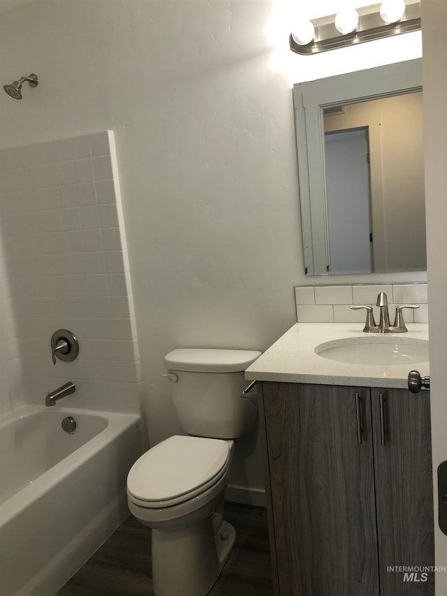 full bathroom with vanity, backsplash, shower / washtub combination, toilet, and wood-type flooring