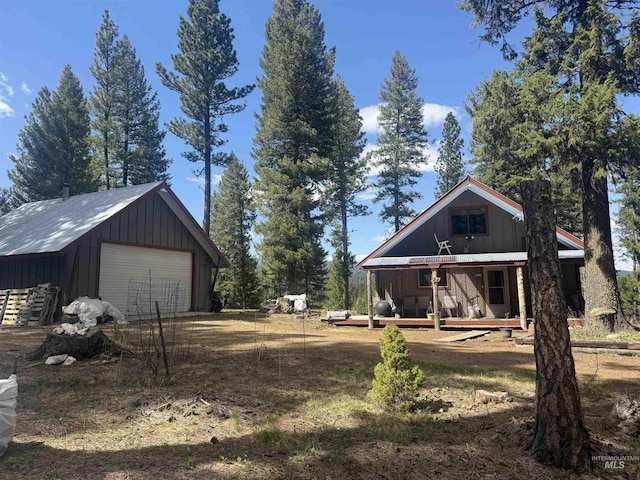 26 Doaka Ct, Idaho City, ID 83631 - view of front of home featuring a detached garage, an outdoor structure, covered porch, and board and batten siding