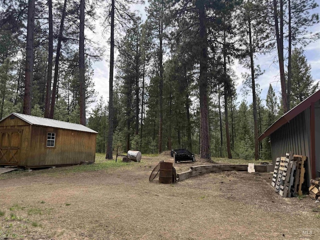 26 Doaka Ct, Idaho City, ID 83631 - view of yard featuring a storage shed, an outdoor structure, and a view of trees