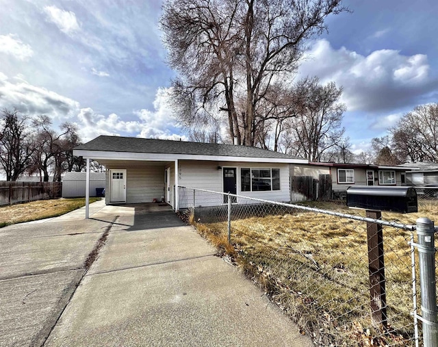 ranch-style home with a fenced front yard, a carport, and concrete driveway