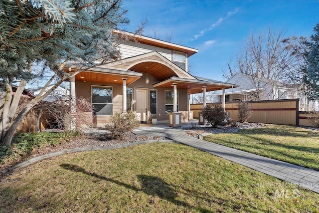 rear view of house with a yard and fence