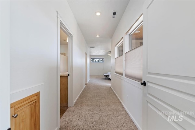 hall with baseboards, recessed lighting, visible vents, and light colored carpet