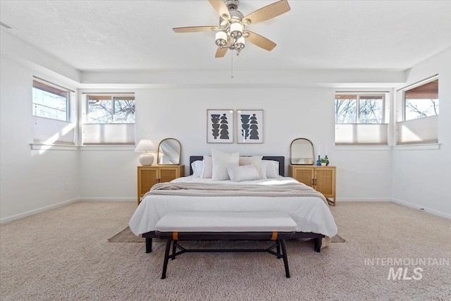 bedroom with light carpet, ceiling fan, and baseboards