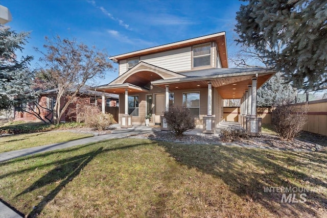 view of front of house with a front yard, covered porch, and fence