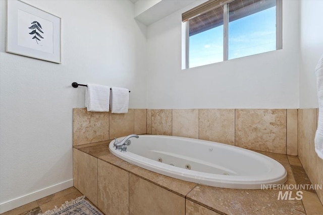 bathroom featuring a whirlpool tub and baseboards