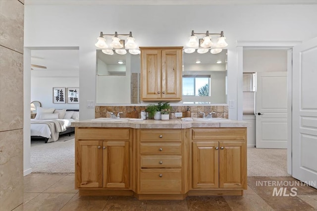 ensuite bathroom featuring a sink, ensuite bathroom, and double vanity