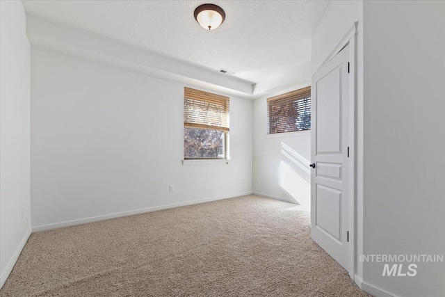 empty room featuring baseboards, a textured ceiling, visible vents, and carpet flooring