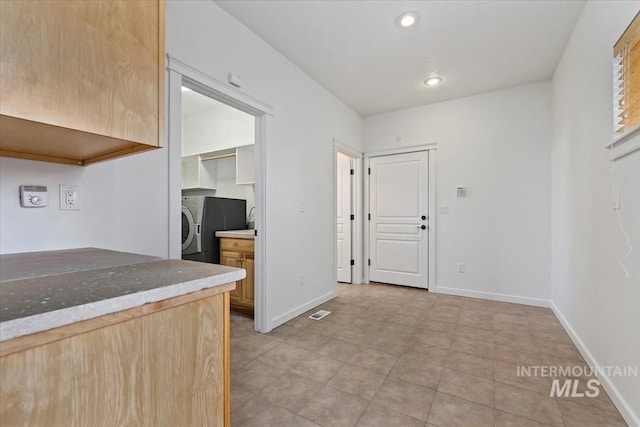 kitchen with recessed lighting, fridge, light brown cabinets, and baseboards