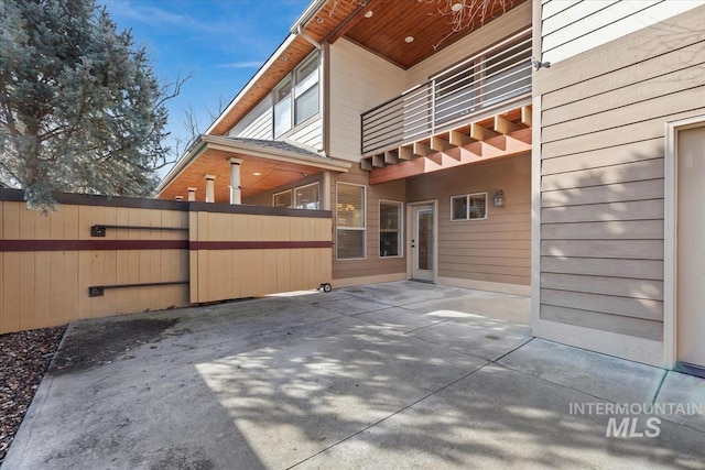 back of house featuring a patio area, fence, and a balcony