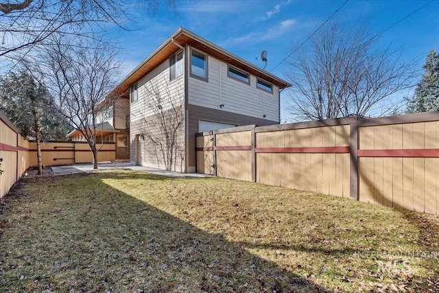 rear view of house with a garage, fence, and a lawn