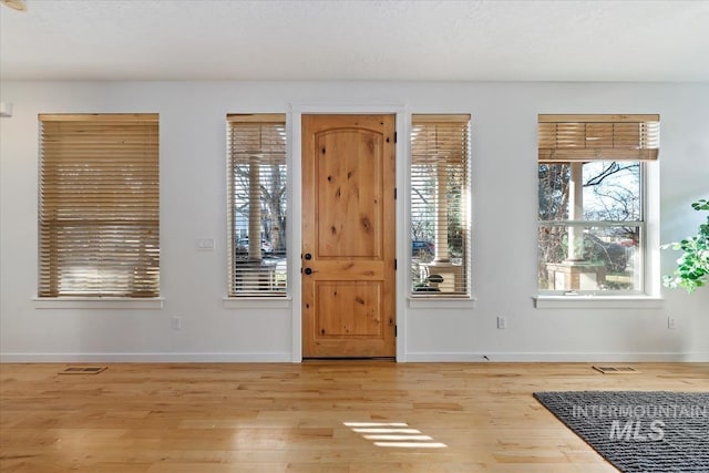 entryway with baseboards, visible vents, and light wood-style floors