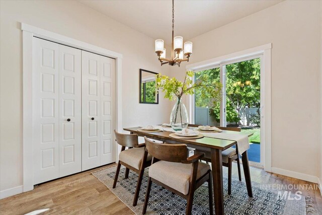 dining room with light hardwood / wood-style flooring and a notable chandelier