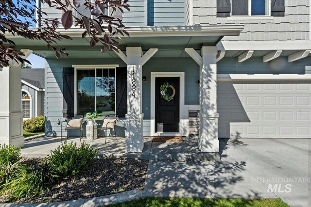 doorway to property with a porch and a garage