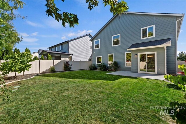 rear view of house featuring a yard and a patio area