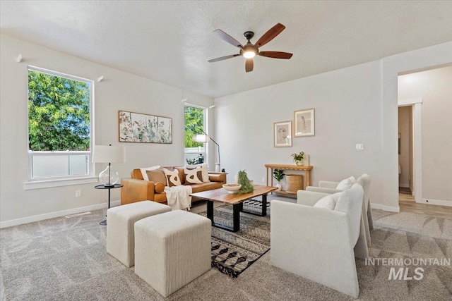 carpeted living room featuring a wealth of natural light, a textured ceiling, and ceiling fan