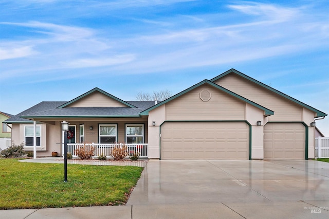 ranch-style house featuring covered porch, a garage, and a front lawn