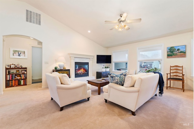 living room with high vaulted ceiling, light colored carpet, and ceiling fan