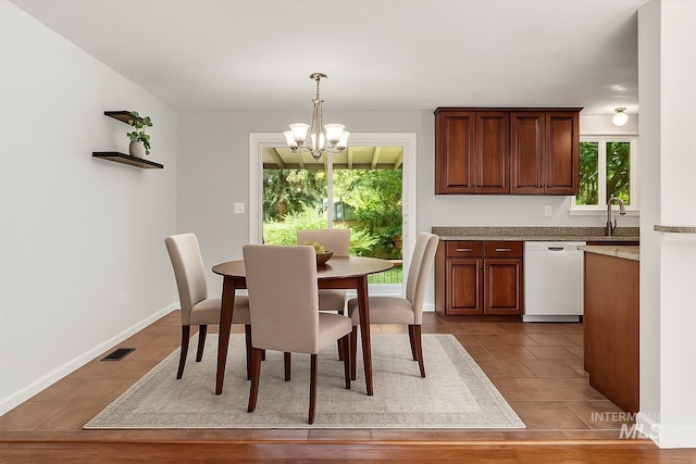 7313 W Court Ave, Boise, ID 83704 - dining area with a chandelier, tile patterned flooring, and baseboards