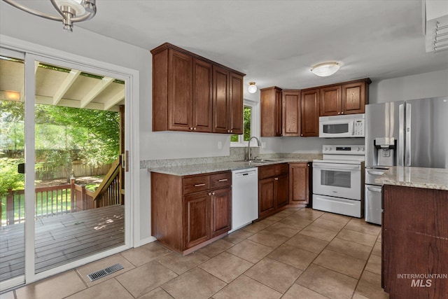 7313 W Court Ave, Boise, ID 83704 - kitchen with white appliances, light stone counters, a sink, and light tile patterned floors