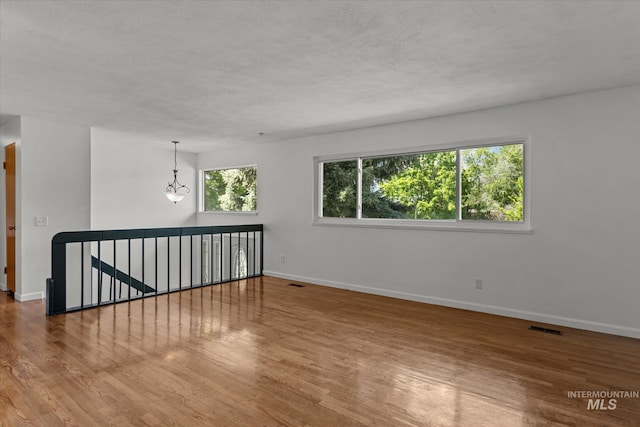 7313 W Court Ave, Boise, ID 83704 - empty room with wood finished floors, a textured ceiling, and baseboards