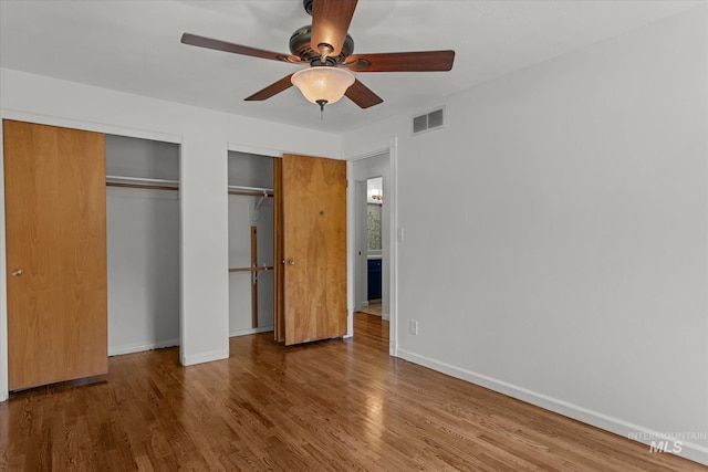 7313 W Court Ave, Boise, ID 83704 - unfurnished bedroom with multiple closets, wood finished floors, baseboards, and a ceiling fan