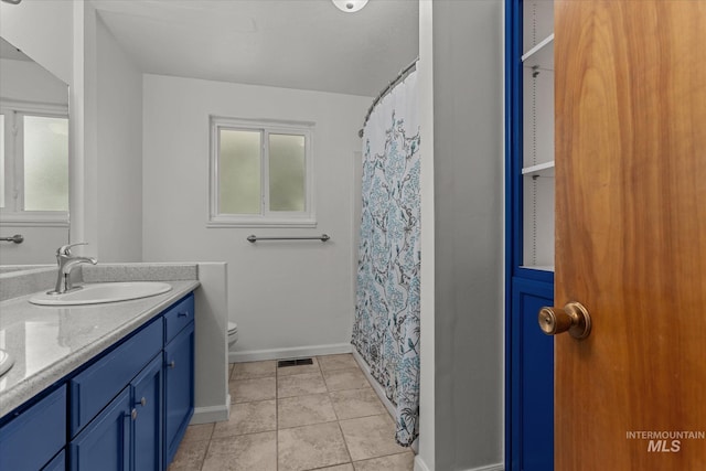 7313 W Court Ave, Boise, ID 83704 - full bath featuring double vanity, baseboards, tile patterned floors, toilet, and curtained shower