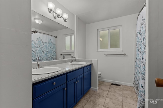 7313 W Court Ave, Boise, ID 83704 - bathroom featuring double vanity, toilet, baseboards, tile patterned flooring, and curtained shower