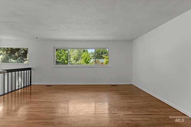 7313 W Court Ave, Boise, ID 83704 - spare room with wood finished floors, baseboards, and a textured ceiling