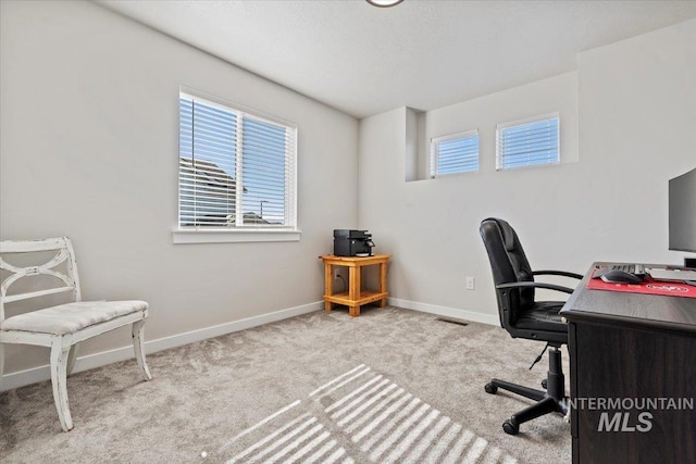 carpeted office space featuring visible vents, plenty of natural light, and baseboards