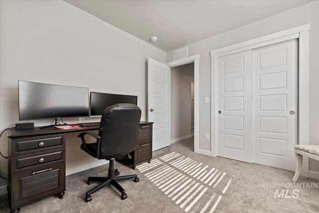 carpeted office with visible vents and baseboards