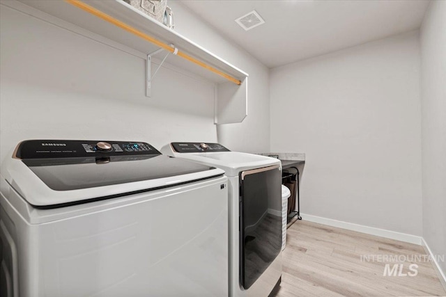 laundry room featuring laundry area, light wood-style flooring, washer and dryer, baseboards, and visible vents