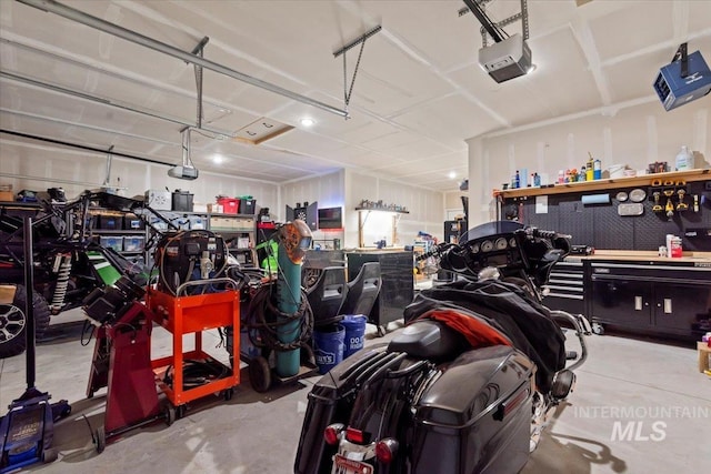 garage with a workshop area and a garage door opener