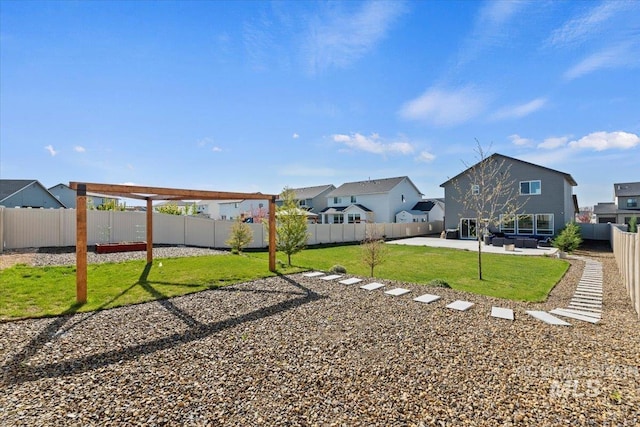 view of yard featuring a patio, a residential view, and a fenced backyard