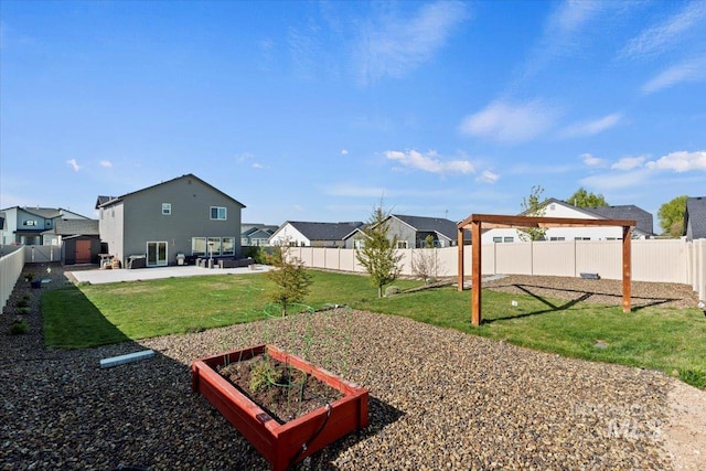 view of yard with a patio area, a garden, a residential view, and a fenced backyard