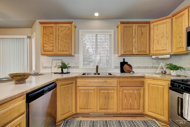 kitchen featuring appliances with stainless steel finishes, light countertops, and a sink