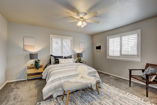 carpeted bedroom featuring baseboards, multiple windows, and a ceiling fan